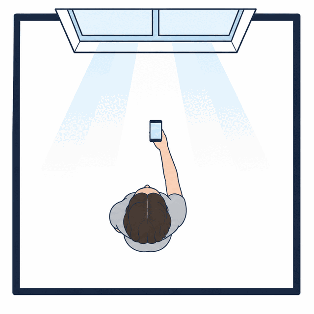 Top-down diagram: daylight from a window falls on the face of a person who faces the window, phone held between them